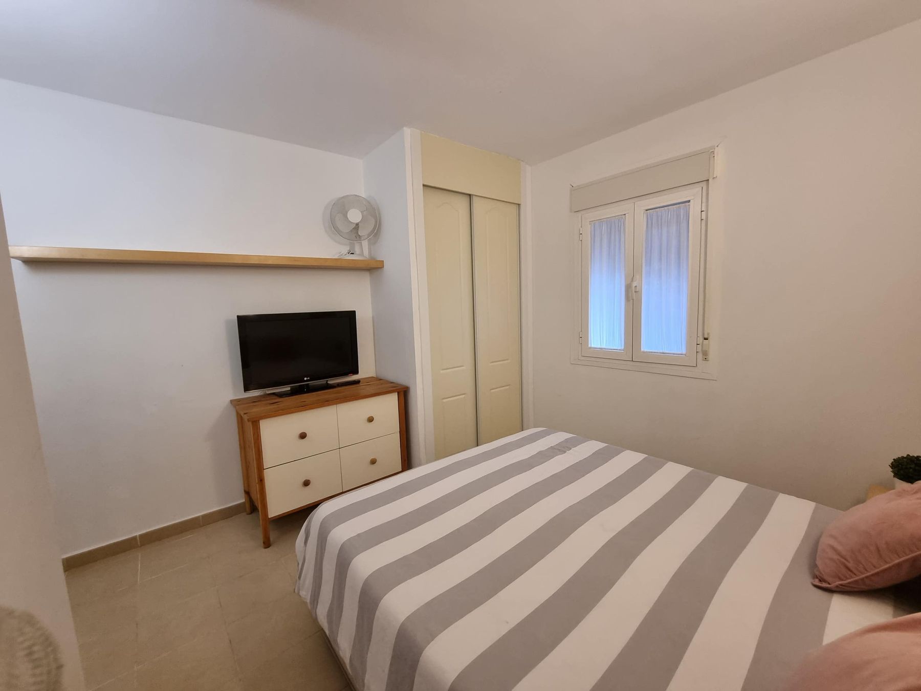 Dormitorio con armario y televisión